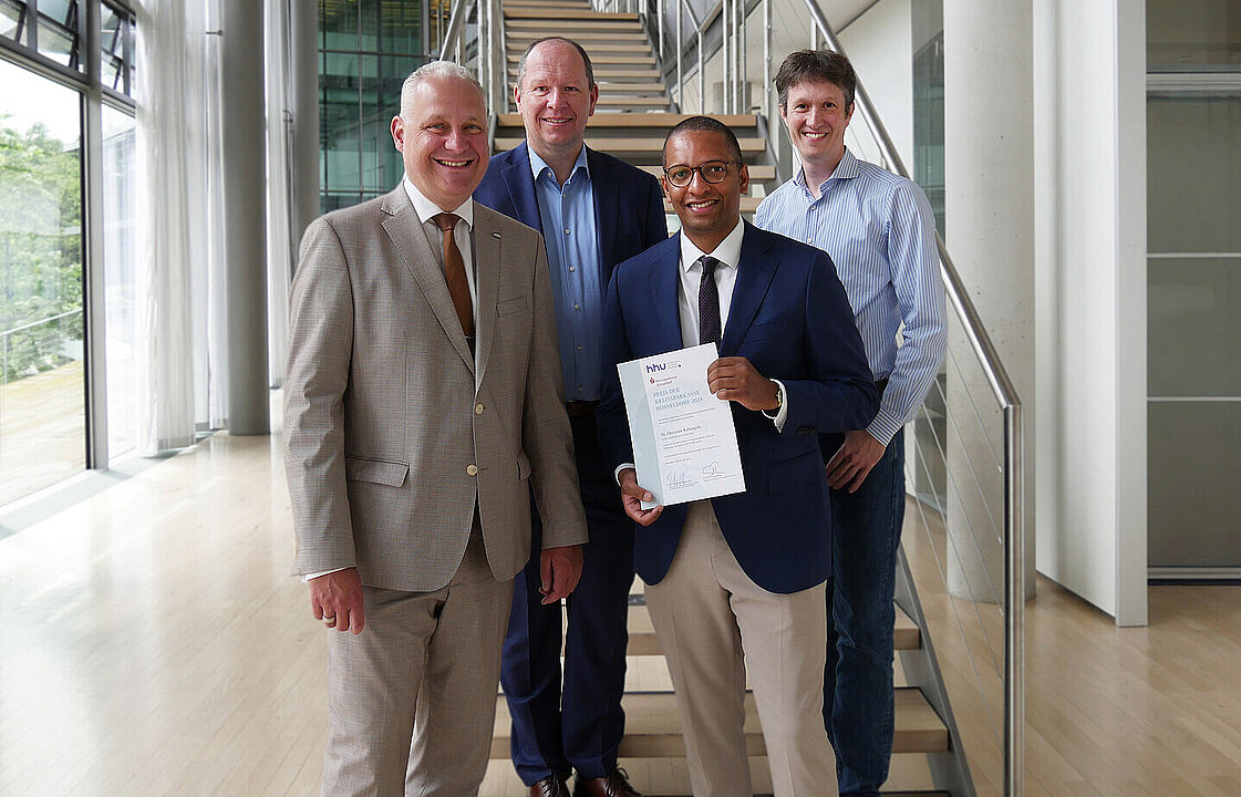 Gruppenbild mit vier Personen in der Wirtschaftswissenschaftlichen Fakultät, Verleihung Promotionspreis 2024 der Kreissparkasse Düsseldorf