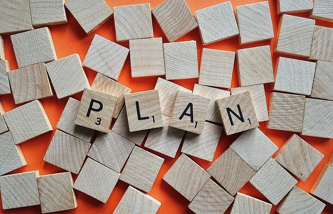 Scrabblesteine, die den Begriff "Plan" bilden