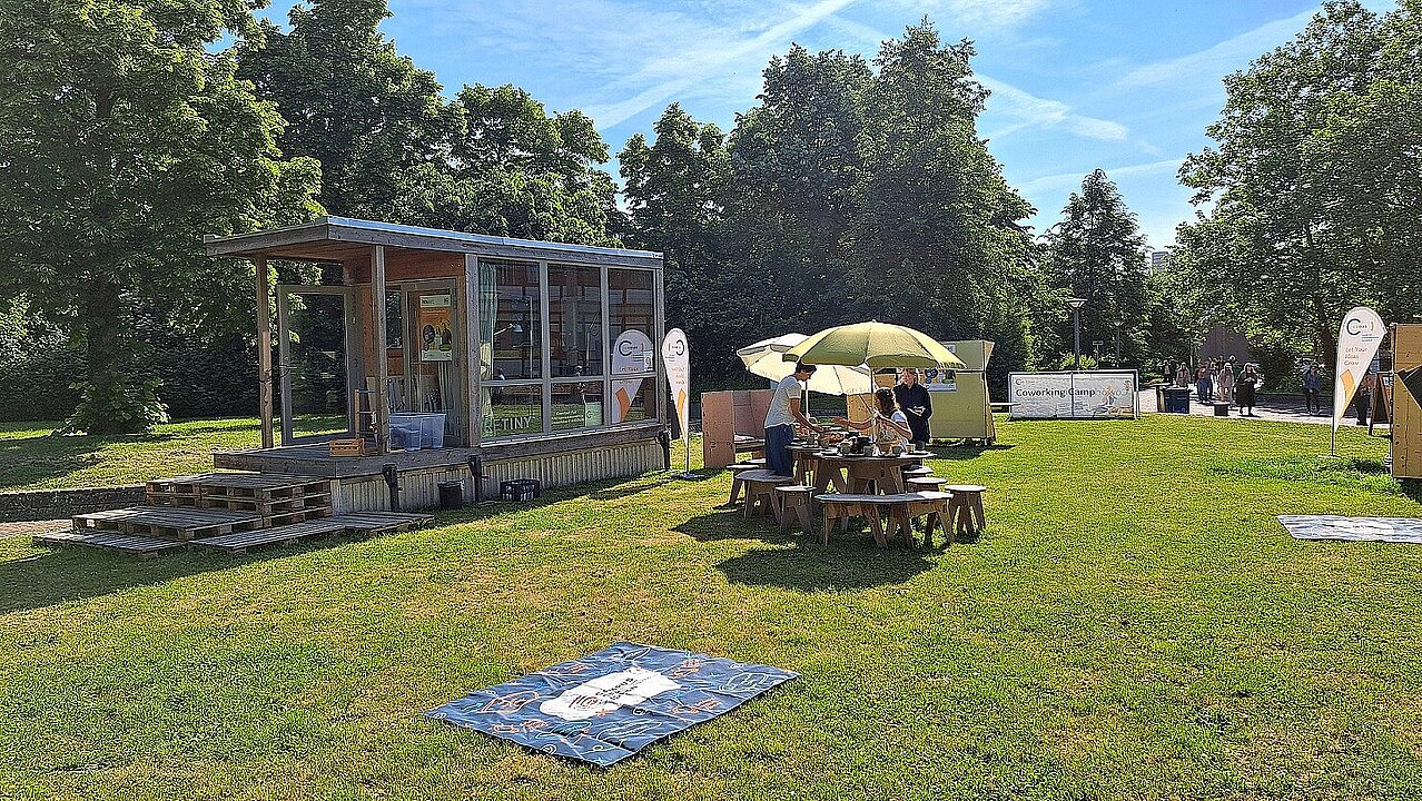 Eine Frühstückstafel auf einer Wiese wird gedeckt