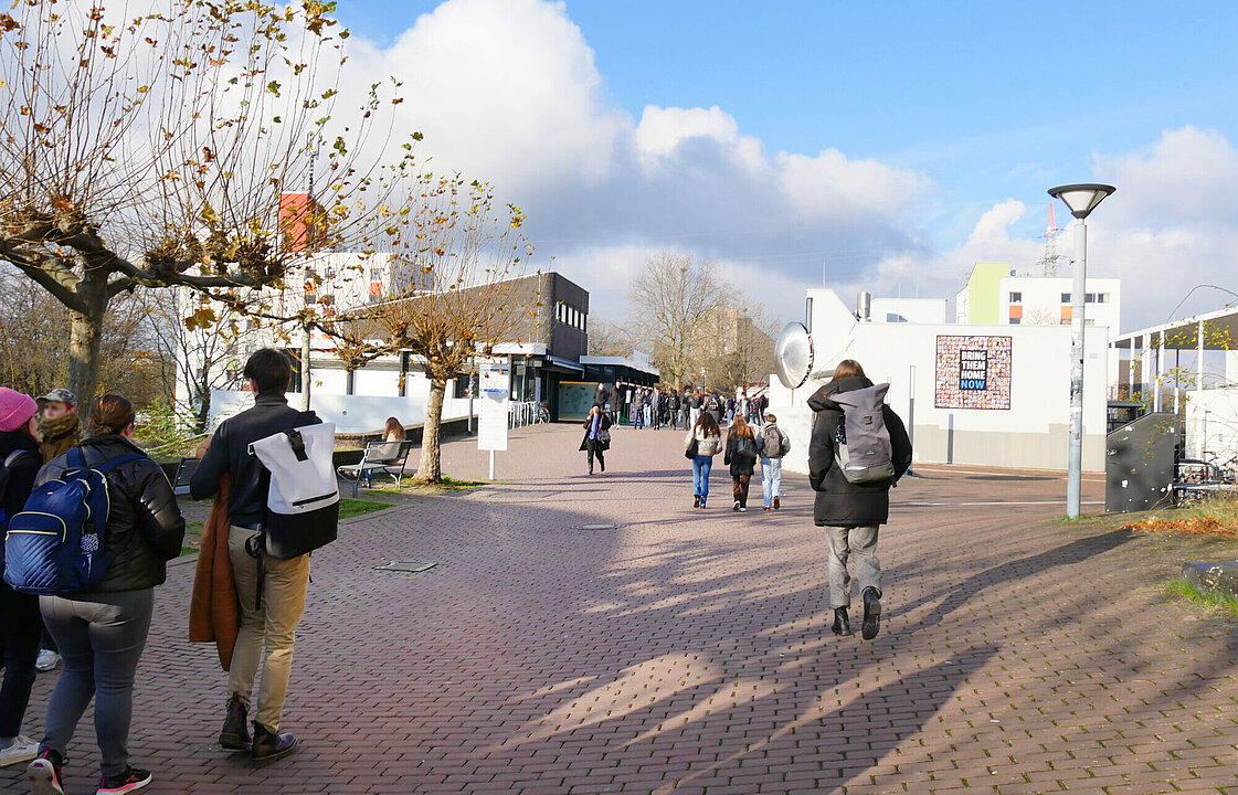 Menschen laufen auf die Mensabrücke zu