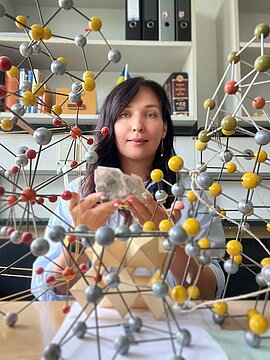 Chemikern Dr. Iryna Konovalova hinter einem Molekülmodell.