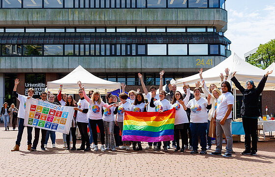 Menschen mit zwei bunten Flaggen in bunten T-Shirts