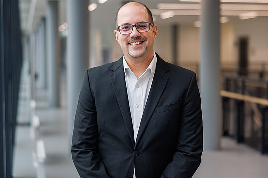 Foto von Jun.-Prof. Dr. Markus Suta in einem Flur an der HHU.
