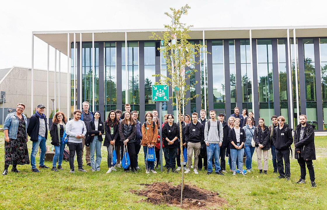 mehrere Menschen stehen auf einer Wiese