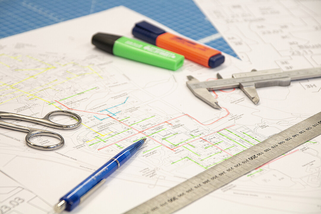 Man sieht einen ausgedruckten Plan der HHU. In bunten Farben sind die Pläne für die Neubelebung der Rohrpostanlage eingezeichent.