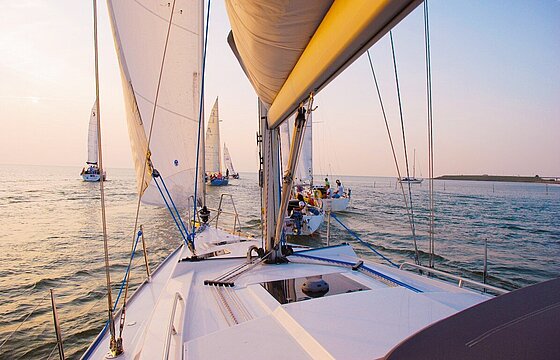 Blick über die Seite eines Segelbootes aufs Wasser