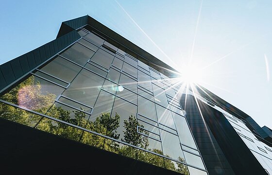 Das Foto zeigt eine begrünte moderne Glasfassade
