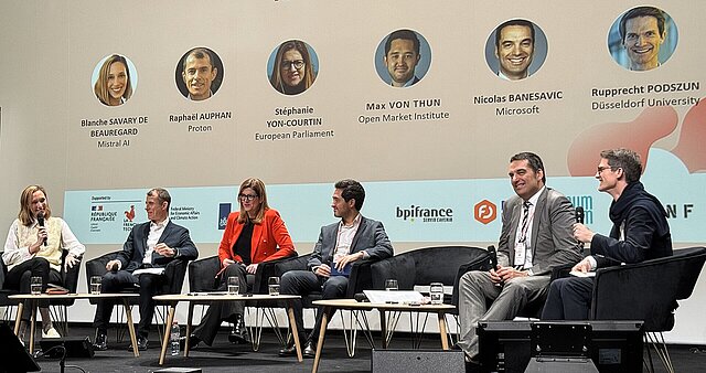 Panelteilnehmende sitzen auf der Bühne