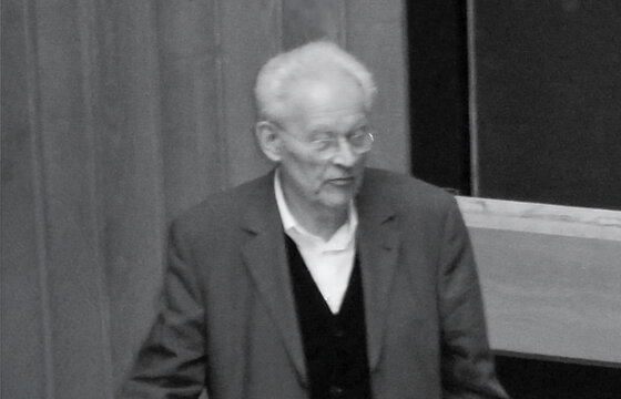 Schwarzweißbild von Prof. Heß im höheren Alter im Hörsaal, im Hintergrund eine Tafel.