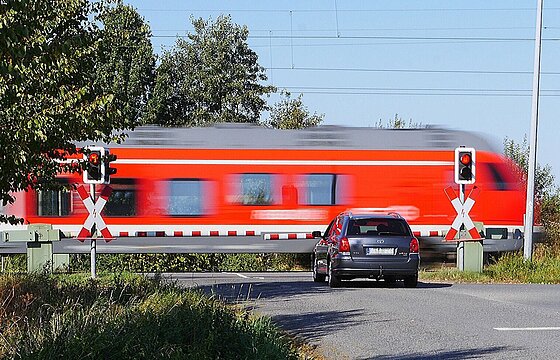 Lok fährt hinter Bahnschranke entlang