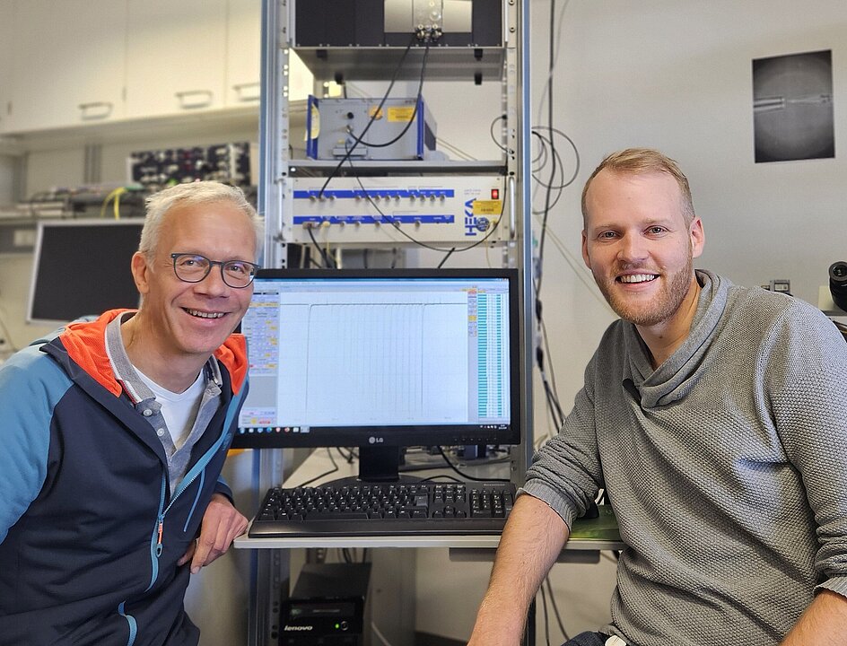 Links: Prof. Dr. Nikolaj Klöcker, Rechts: Dr. Tobias Strasdeit, die beiden sitzen vor einem Bildschirm in ihrem Labor