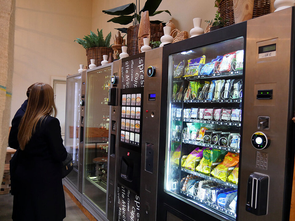 Eine Person steht vor mehreren Automaten