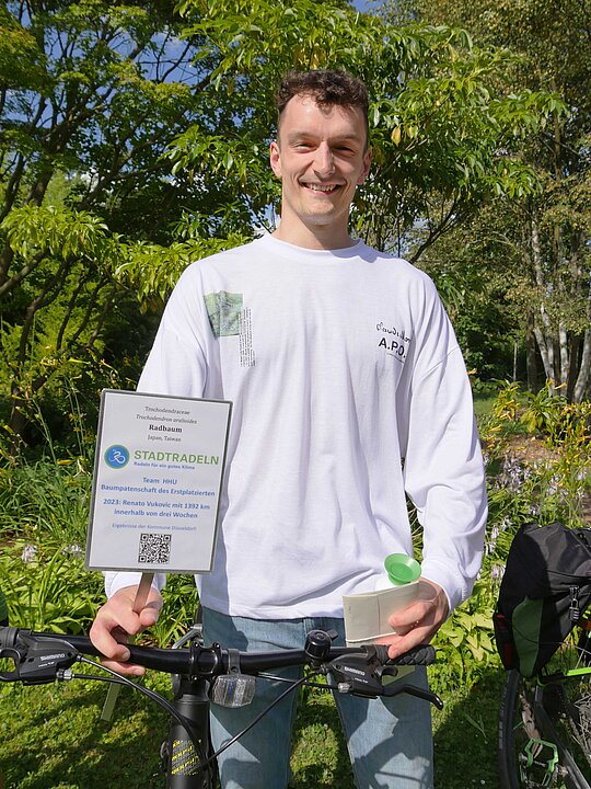 Mensch mit Fahrrad und Urkunde