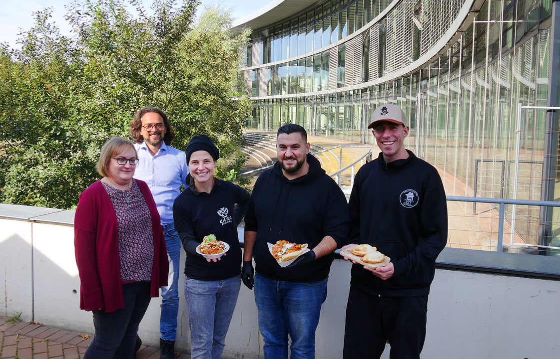 Menschen mit Essen in der Hand vor dem Oeconomicum