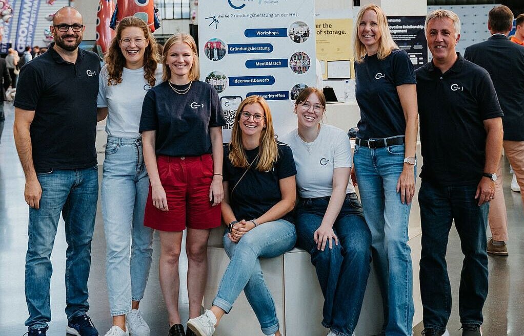 Team des CEDUS im Ausstellungsgelände, stehend und sitzend als Gruppe