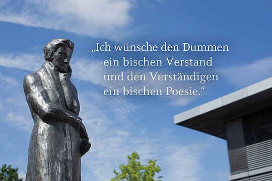 Bildmontage: Schriftzug "Ich wünsche den Dummen ein bischen Verstand und den Verständigen ein bischen Poesie" vor Bild vom HHU-Campus mit der Heinrich-Heine-Statue auf dem ULB-Platz.