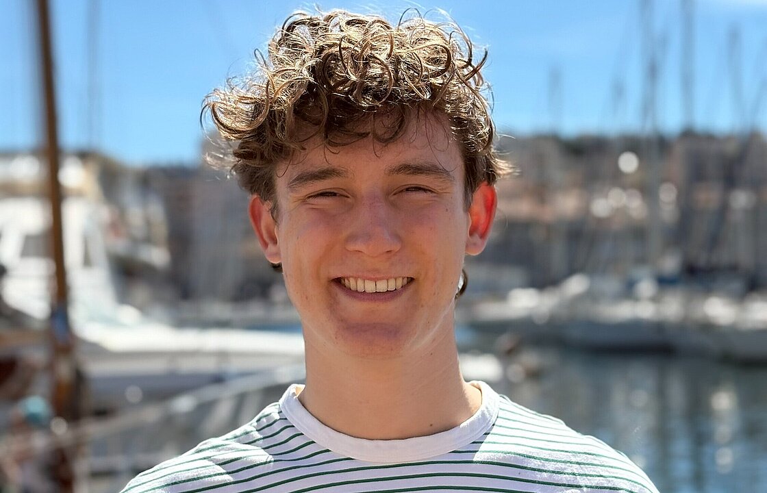 Eine Person steht vor Booten an einem Hafen