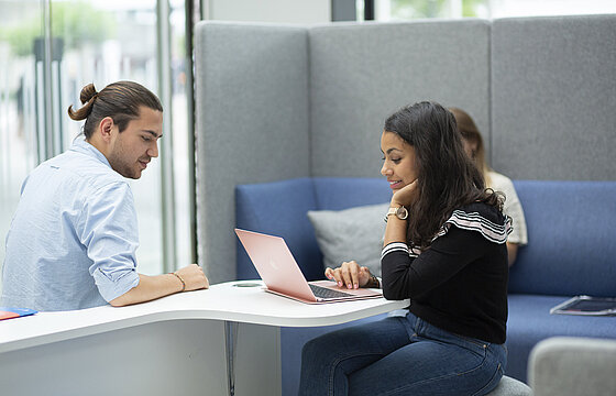 Studierende sitzen im Foyer des SSC