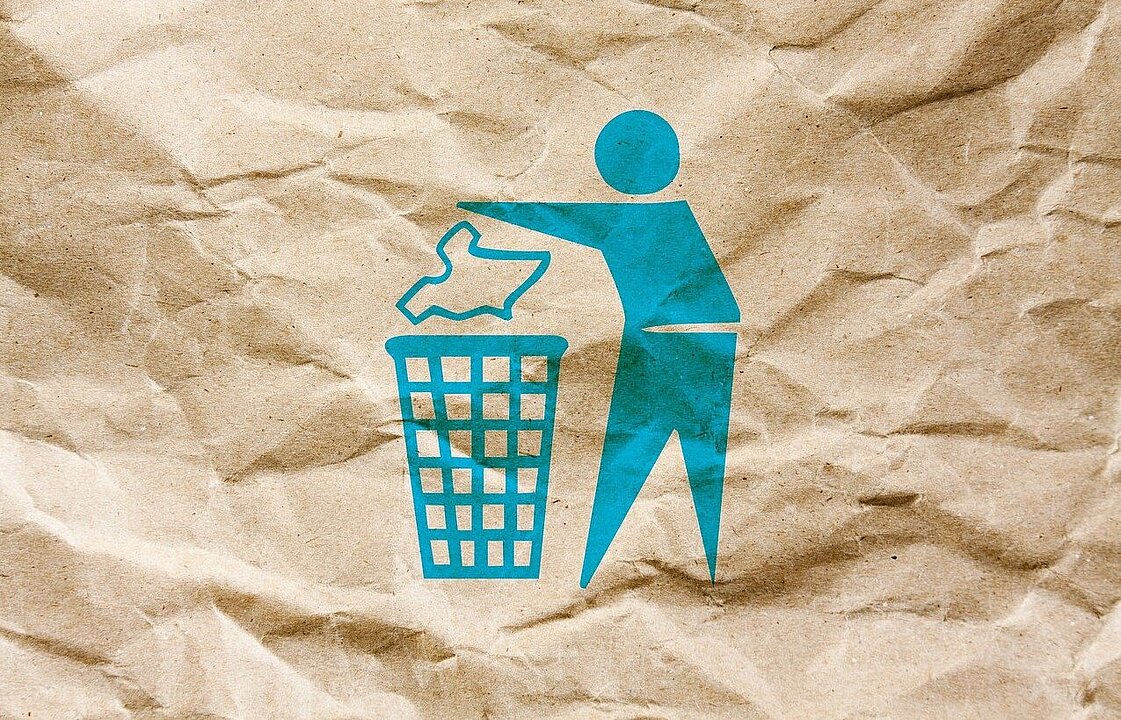Eine stilisierte Person wirft etwas in einen Abfallkorb