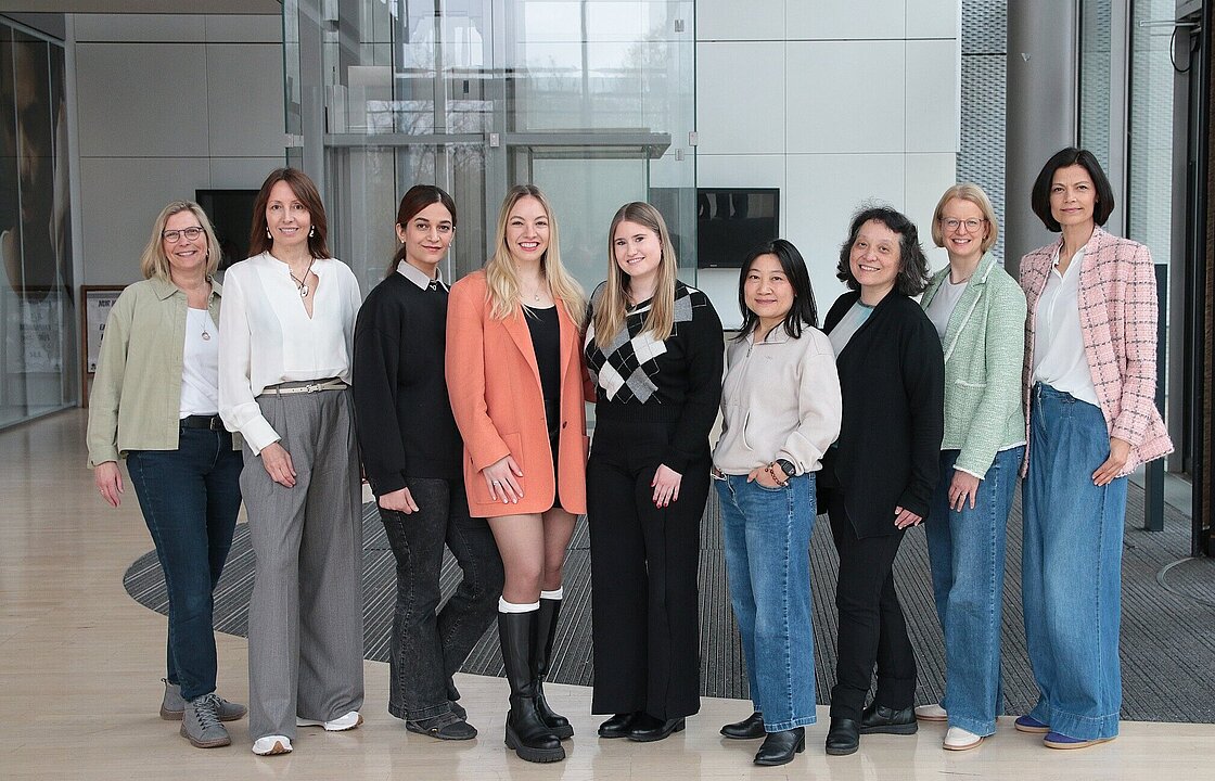 Neun Personen schauen in eine Kamera