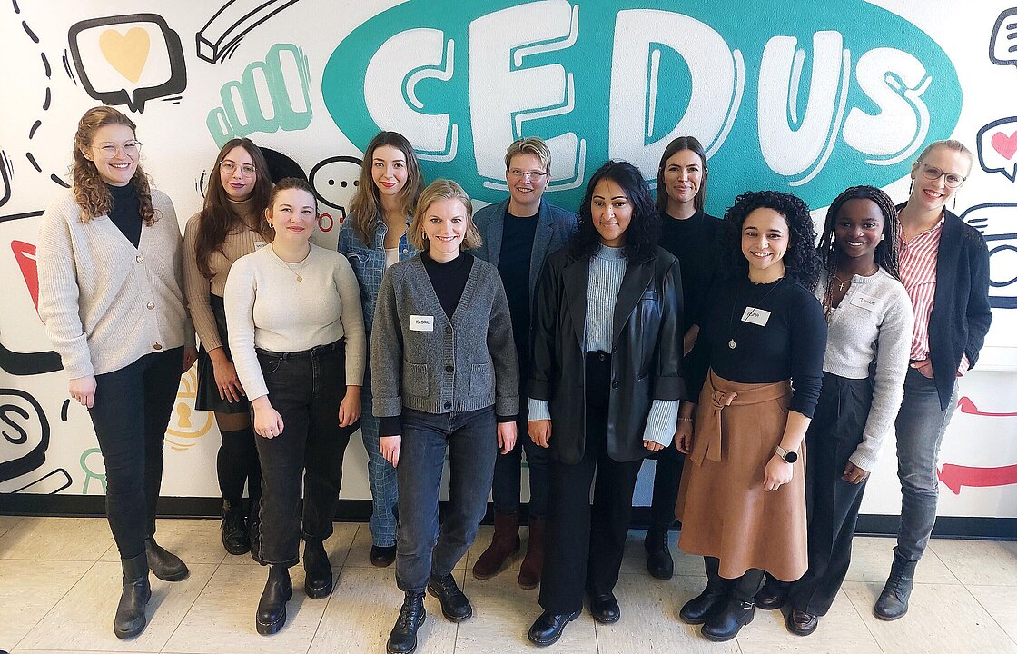 Mehrere Personen vor einer bunten Wand