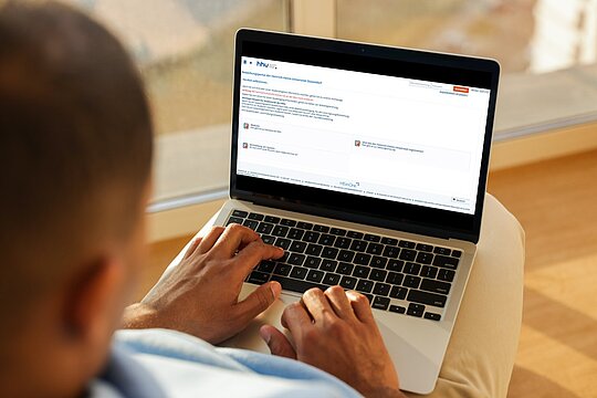 Blick über die Schulter eines Menschen auf Laptop mit HISinOne