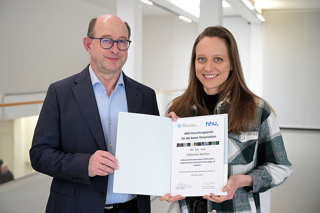 Zwei Personen, die die Preisurkunde für die Beste Dissertation in der Graduiertenschule MOI IV halten.