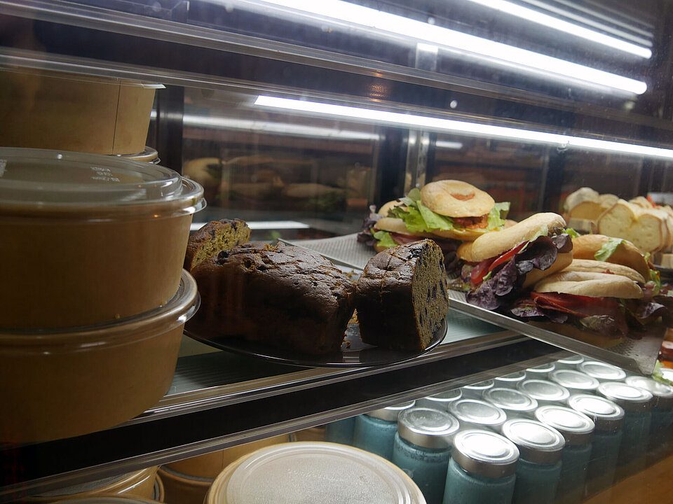 Blick in eine Kuchenvitrine mit Bananenbrot und belegten Bagels