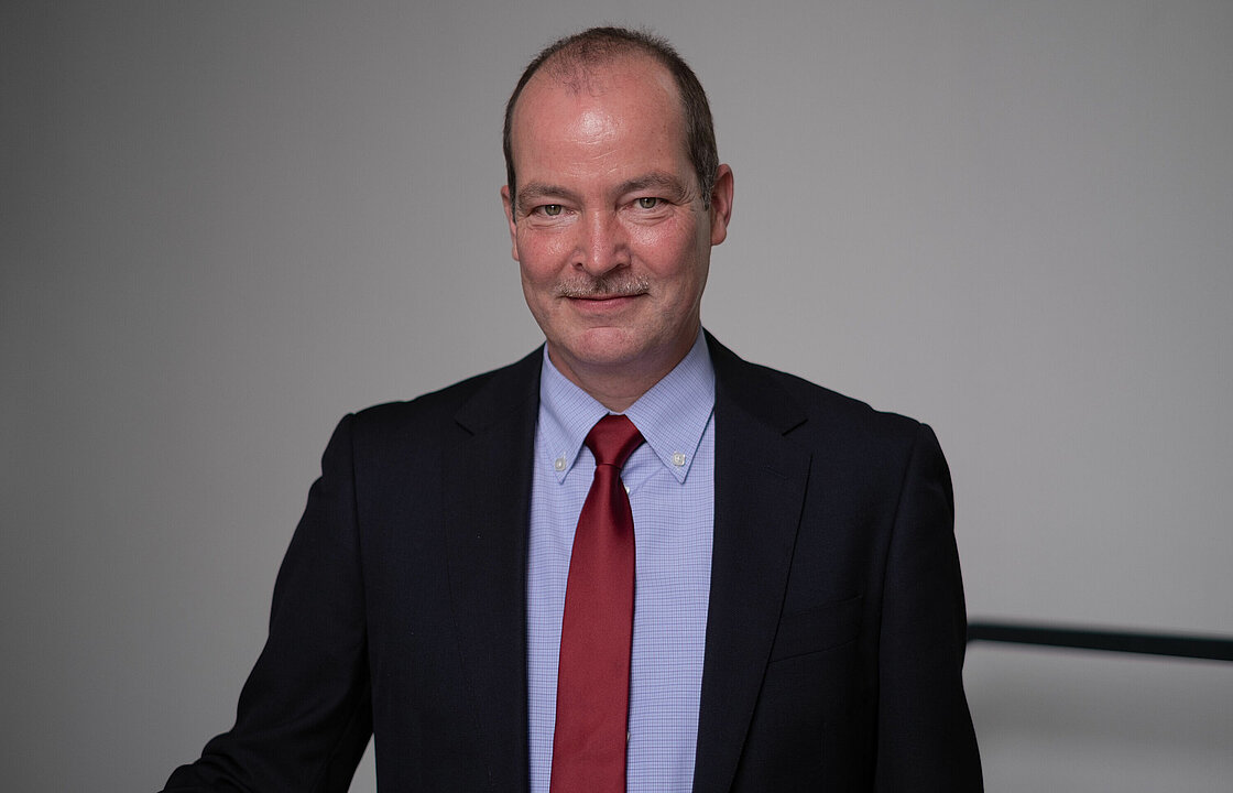 Ein Halbportrait einer Person im Anzug