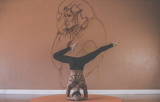 Eine Person im yogischen Kopfstand