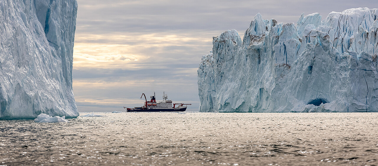 Schiff, rechts und links ein hoher Eisberg