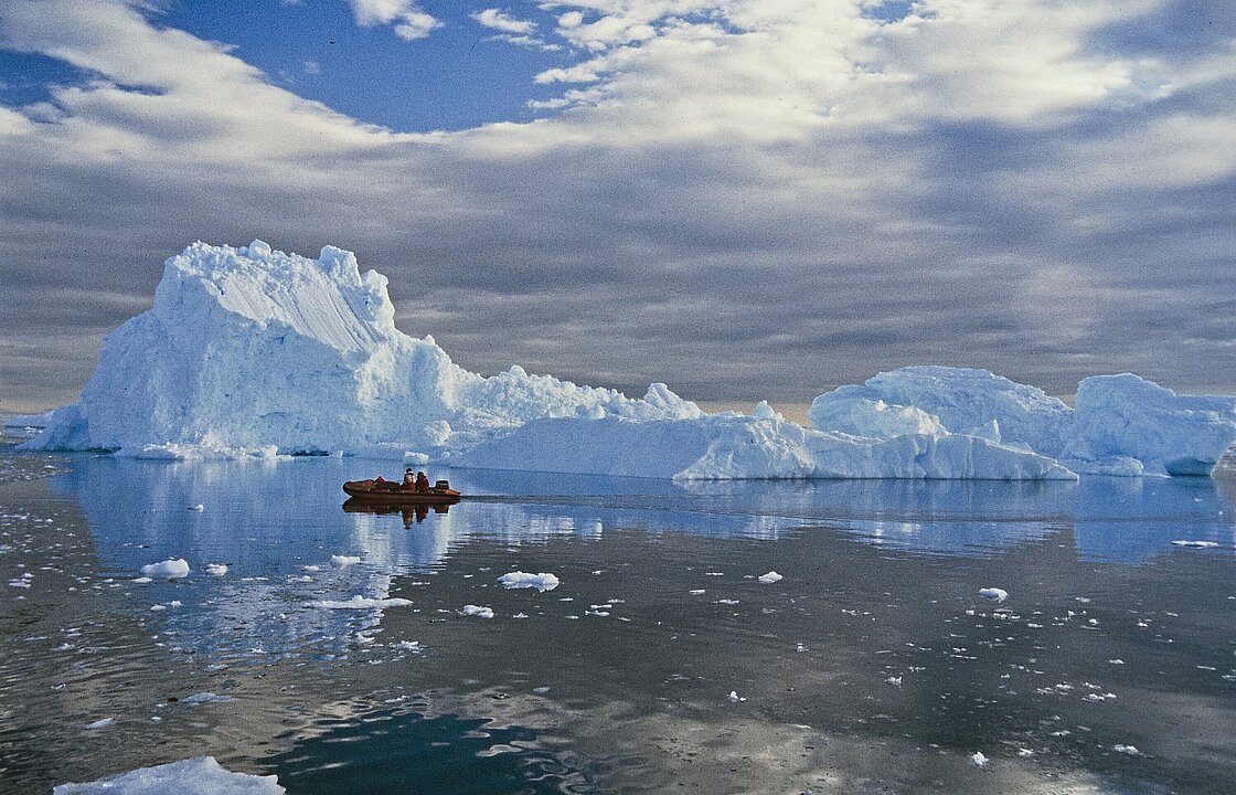 Eisberg im Meer, mit Boot im Vordergrund