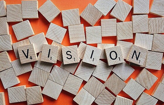 Das Wort "Vision", gelegt mit Scrabblesteinen.