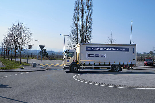 Lkw mit der Aufschrift "Antimatter in motion" in einem Kreisverkehr.