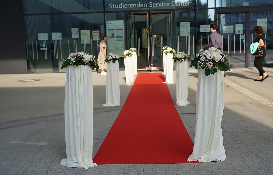 roter Teppich, der zwischen Blumen zum SSC führt