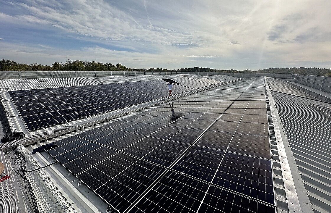 Photovoltaikmodule auf dem Dach des Parkhauses P1, dazwischen läuft eine Person entlang