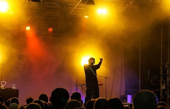 Ein Musiker auf beleuchteter Bühne