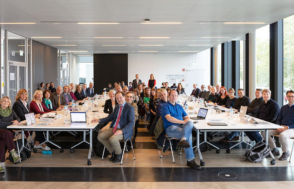 Viele Personen an zwei langen Tischen im SSC