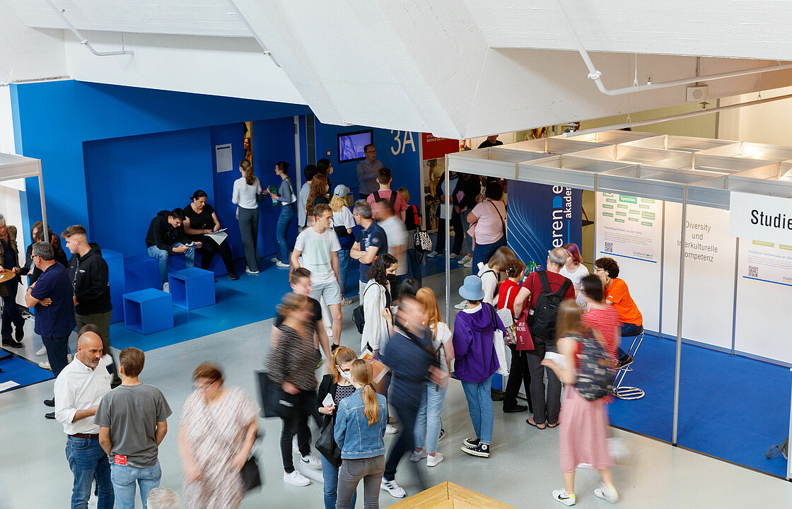 Studierende im Foyer vor Hörsaal 3A an Info-Ständen