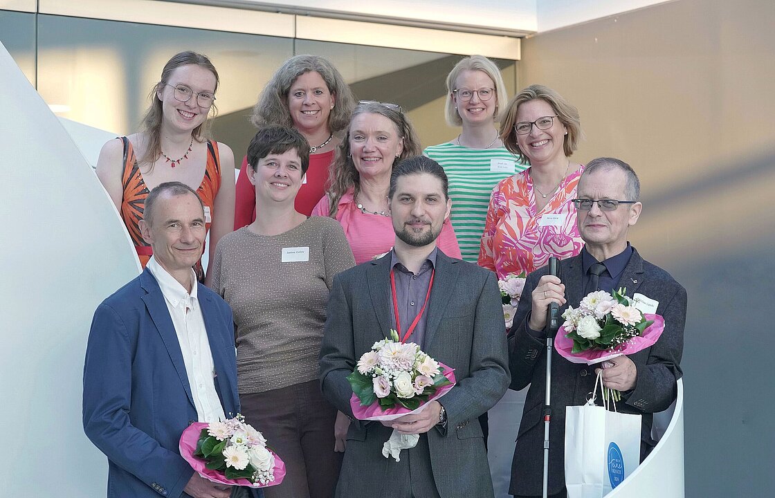 Auf dem Foto sind die neun Heine-Menschen zu sehen, die bei einem festlichen Abend am Campus ausgezeichnet wurden. In der vorderen Reihe stehen, von links nach rechts: Prof. Dr. Christoph Janiak, Janine Golov, Julian Junggeburth, Zdzislaw Lipski. In der hinteren Reihe stehen: Magdalena Kuom, Anne Rubens-Laarmann, Prof. Dr. Ute J. Bayen, Prof. Dr. Eva Lutz, Nina Berg