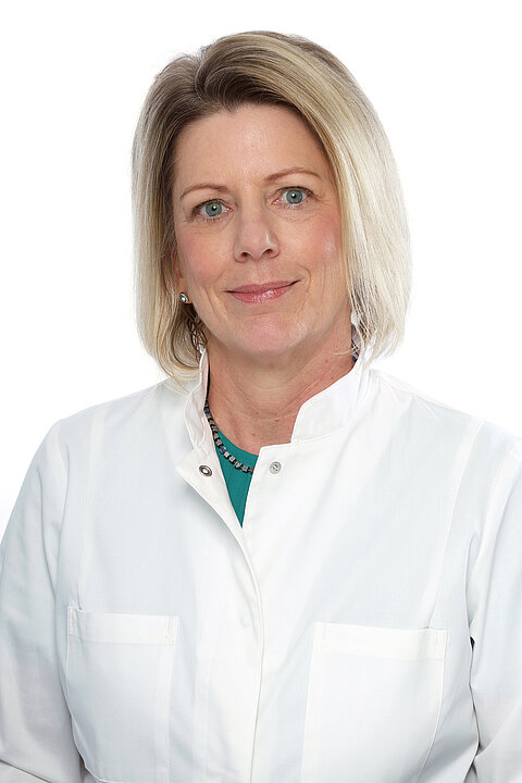 Portraitfoto von Dr. Tanja Freundl-Schütt. Sie hat schulterlange, blonde Haare und trägt einen weißen Kittel.