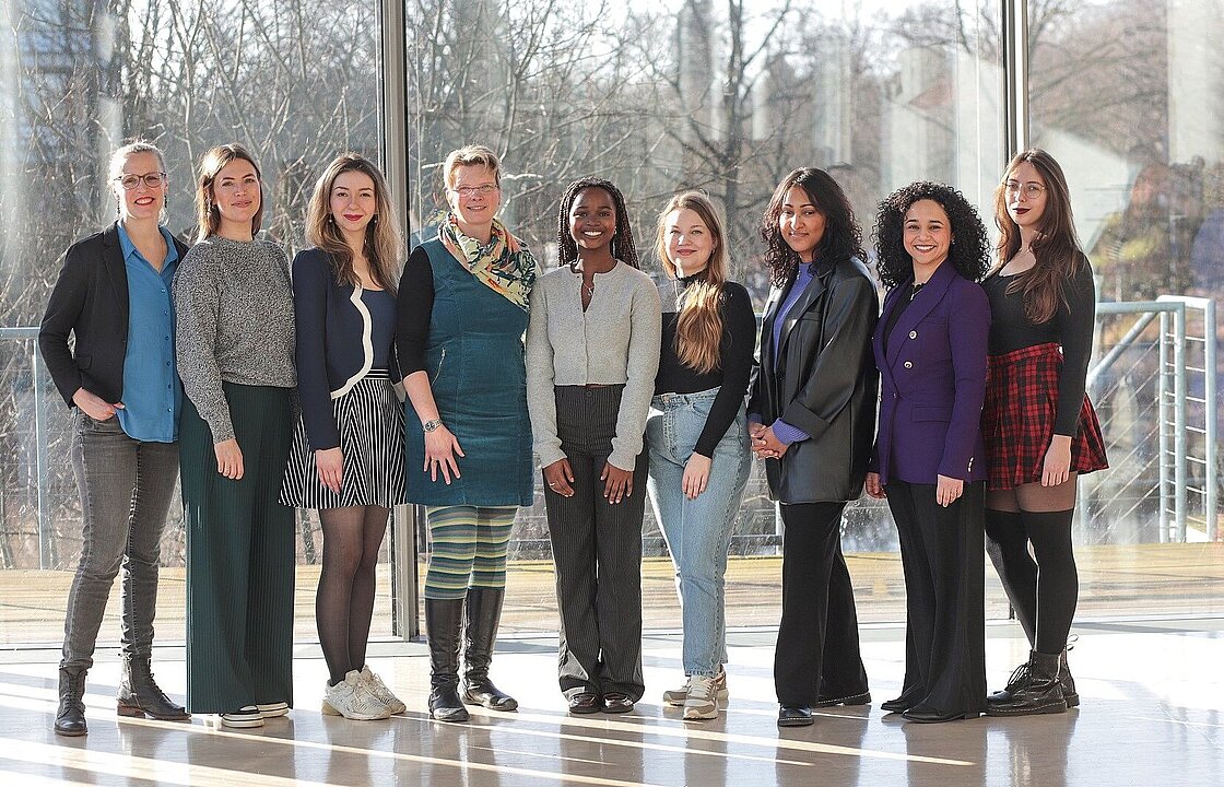 Mehrere Personen stehen vor einer großen Fensterfront