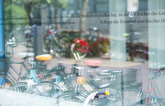 Fahrräder spiegeln sich in einer Fensterscheibe