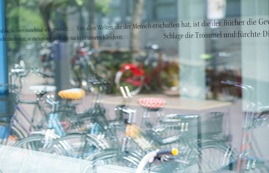 Fahrräder spiegeln sich in einer Fensterscheibe