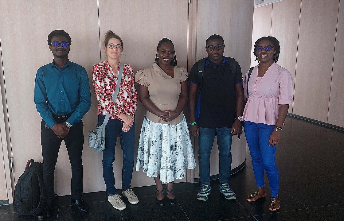 Fünf Personen stehen vor der Tür eines Sitzungssaals.